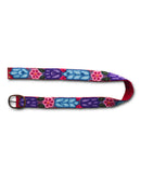 Der Ayni Pacha Gürtel "Jara" ist auf einem weißen Hintergrund flach gelegt und präsentiert das gesamte bunt bestickte Blumenmuster sowie die Wolltextur.