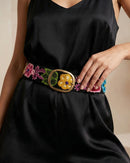 Detailansicht der bunten floralen Handstickerei auf dem schwarzen Gürtel 'Aralia' aus 100% Schafwolle, mit Fokus auf die ovale, messingfarbene Metallschnalle.