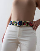Ayni Ppacha Gürtel Ramo für Damen, in Peru aus Wolle bestickt mit bunten Blumen auf weißer Basis, stilvoll kombiniert als elegantes Boho Chic Outfit.