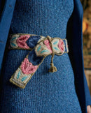 Detailansicht der handbestickten Blätter (Pink, Blau) auf dem olivgrünen Wollgürtel 'Morera', mit Fokus auf die Textur und die dezente, silberne Schnalle.