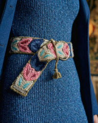 Detailansicht der handbestickten Blätter (Pink, Blau) auf dem olivgrünen Wollgürtel 'Morera', mit Fokus auf die Textur und die dezente, silberne Schnalle.