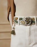 Extreme Nahaufnahme der Textur der 100% Schafwolle und der handgefertigten Stickerei des Gürtels 'Nolina', die die natürliche Haptik und die silberne Schnalle zeigt.