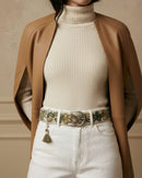 Styling-Inspiration: Der handbestickte Wollgürtel 'Nolina' in Wollweiß und Olivgrün verbindet harmonisch eine weiße Jeans mit einem beigen Rippstrick-Rollkragenpullover.