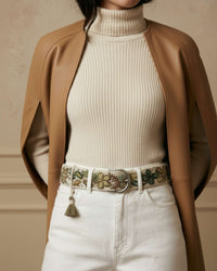 Styling-Inspiration: Der handbestickte Wollgürtel 'Nolina' in Wollweiß und Olivgrün verbindet harmonisch eine weiße Jeans mit einem beigen Rippstrick-Rollkragenpullover.