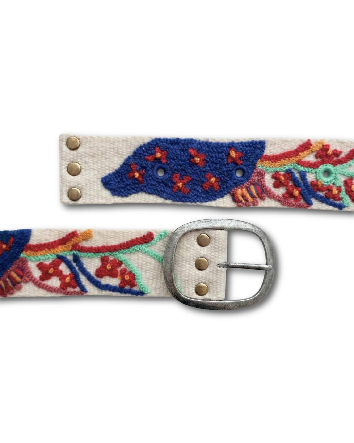 Detailaufnahme der ovalen, silberfarbenen Schnalle und der genieteten Verschlusslöcher des Ayni Ppacha Gürtels 'Piri Piri', die die robuste handwerkliche Verarbeitung zeigt.